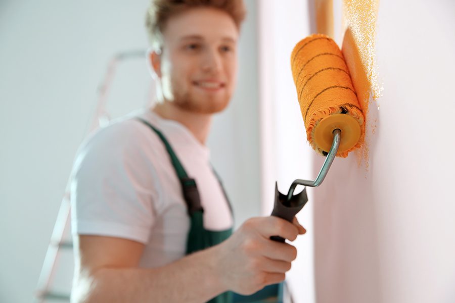 Professional Services Insurance - Professional Decorator Painting Wall Indoors for a Home Repair Service