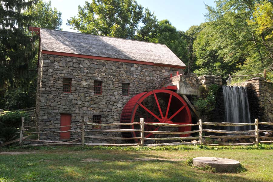Sudbury, MA - Landscape View Of Old Stone Grist Water Mill with a Red Wheel in Sudbury, MA